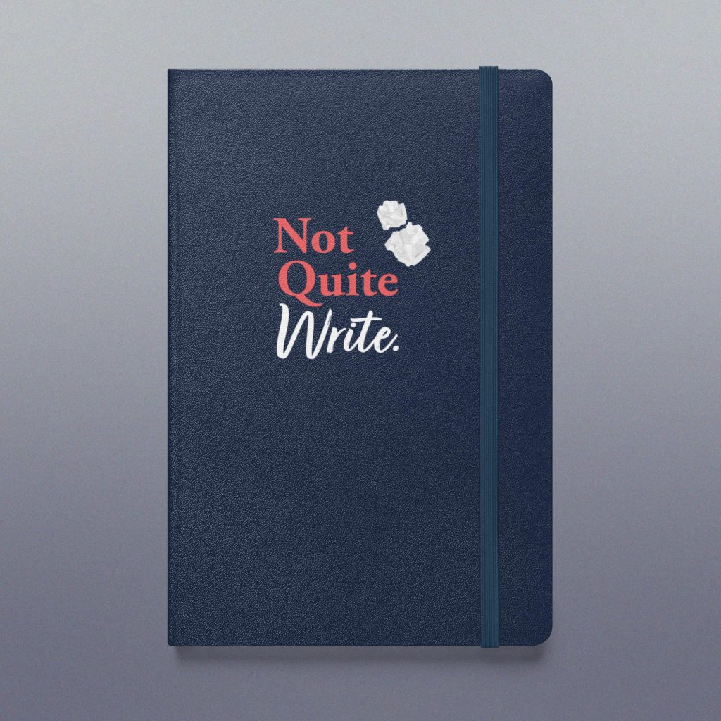 Navy notebook featuring the Not Quite Write logo and an elastic closure/bookmark.